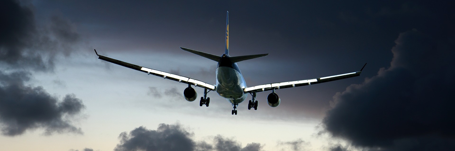 plane flyign towards dark clouds